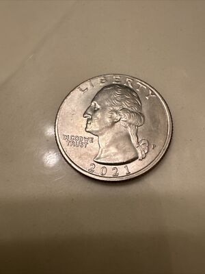 2021 quarter off-center strike error — partial design visible with blank crescent-shaped planchet area where the die failed to fully strike the coin